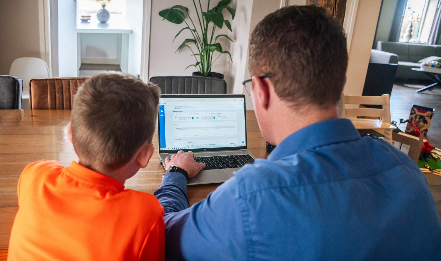 Melkveehouder Martin Brandsma met zoon achter computer met data uit DeLaval Milk Solids Analysis in DeLaval Plus