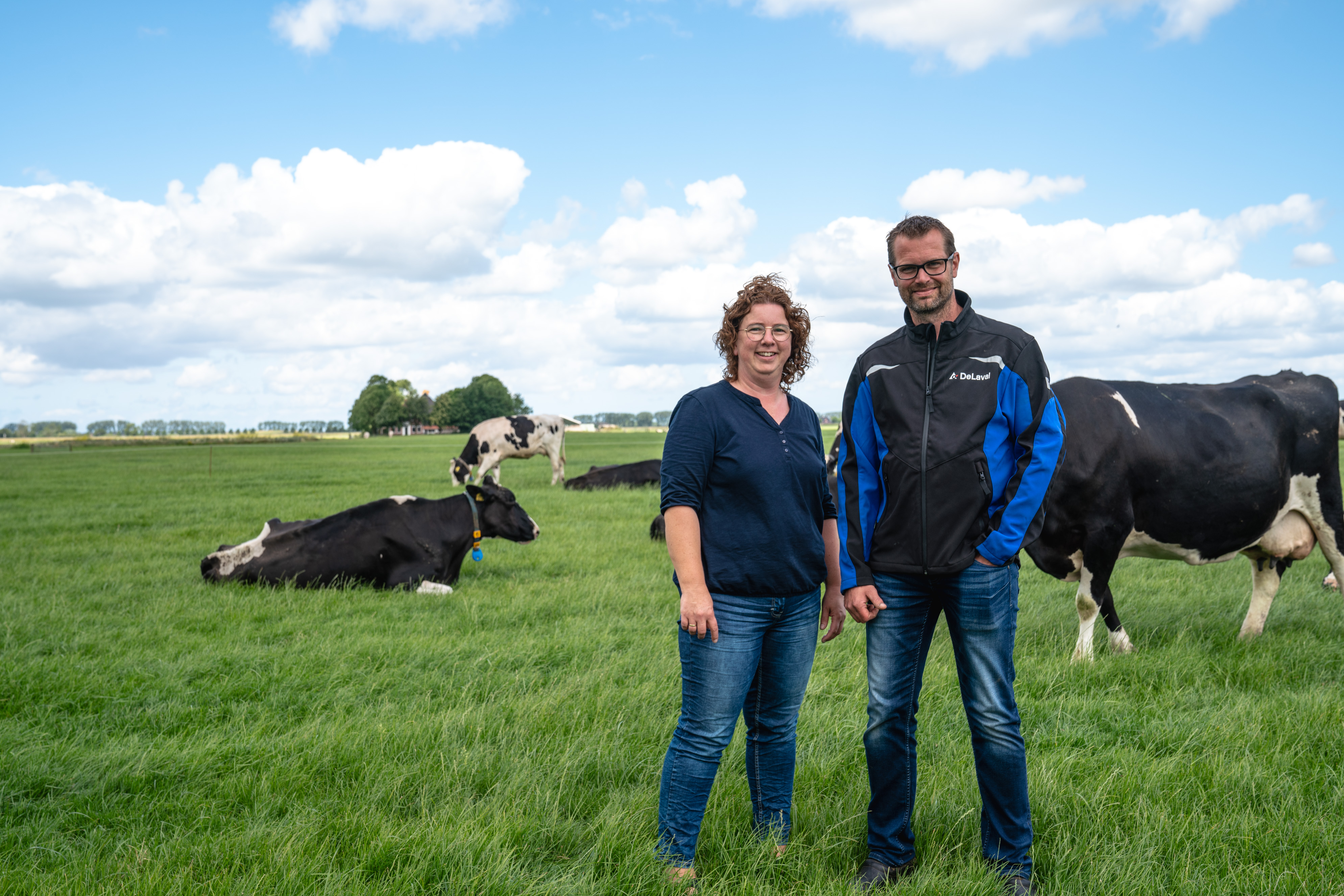 Melkveehouder Uilke Dijkstra met vrouw in het weiland met de melkkoeien