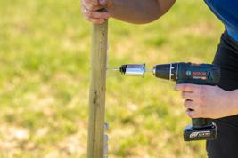 Mounting tool in metal with ring insulator mounted on wooden post