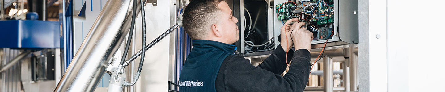 Técnico de servicio DeLaval trabajando en robot de ordeño