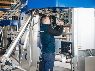 Técnico de servicio DeLaval trabajando en un robot de ordeño DeLaval VMS
