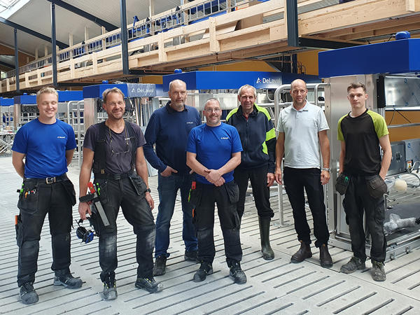 Familjen Eng och DeLaval personal står framför flera VMSer i samband med montering av robotarna.