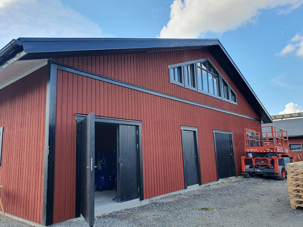 Den nya röda byggnaden där korna mjölkas i 8 VMS mjölkrobotar.
